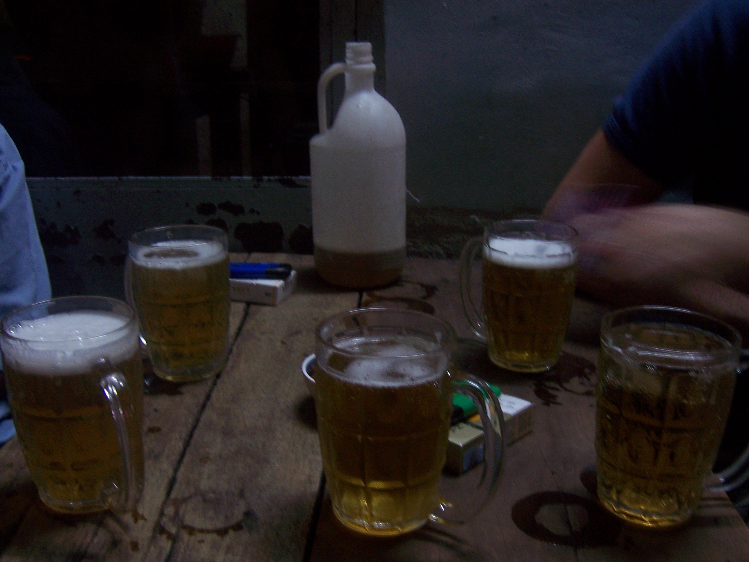 Frosty mugs and a jug of cheap beer on a wooden table