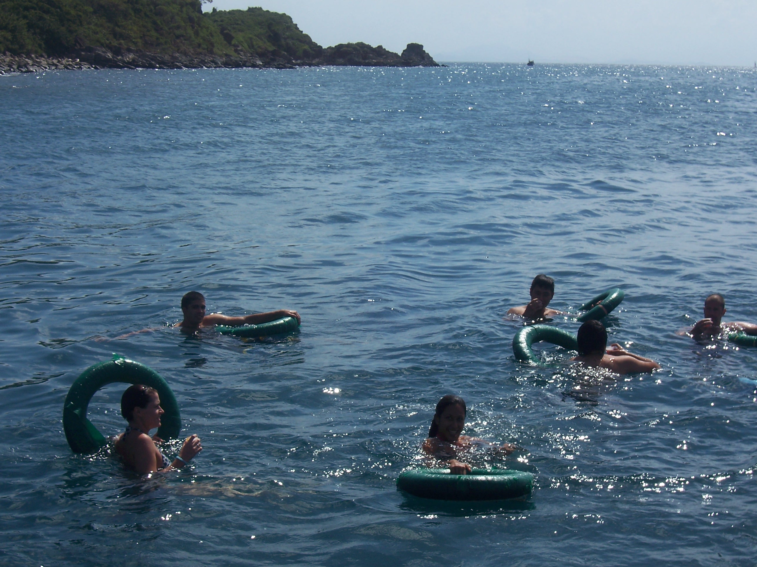 Travellers in inner tubes with drinks at the floating bar