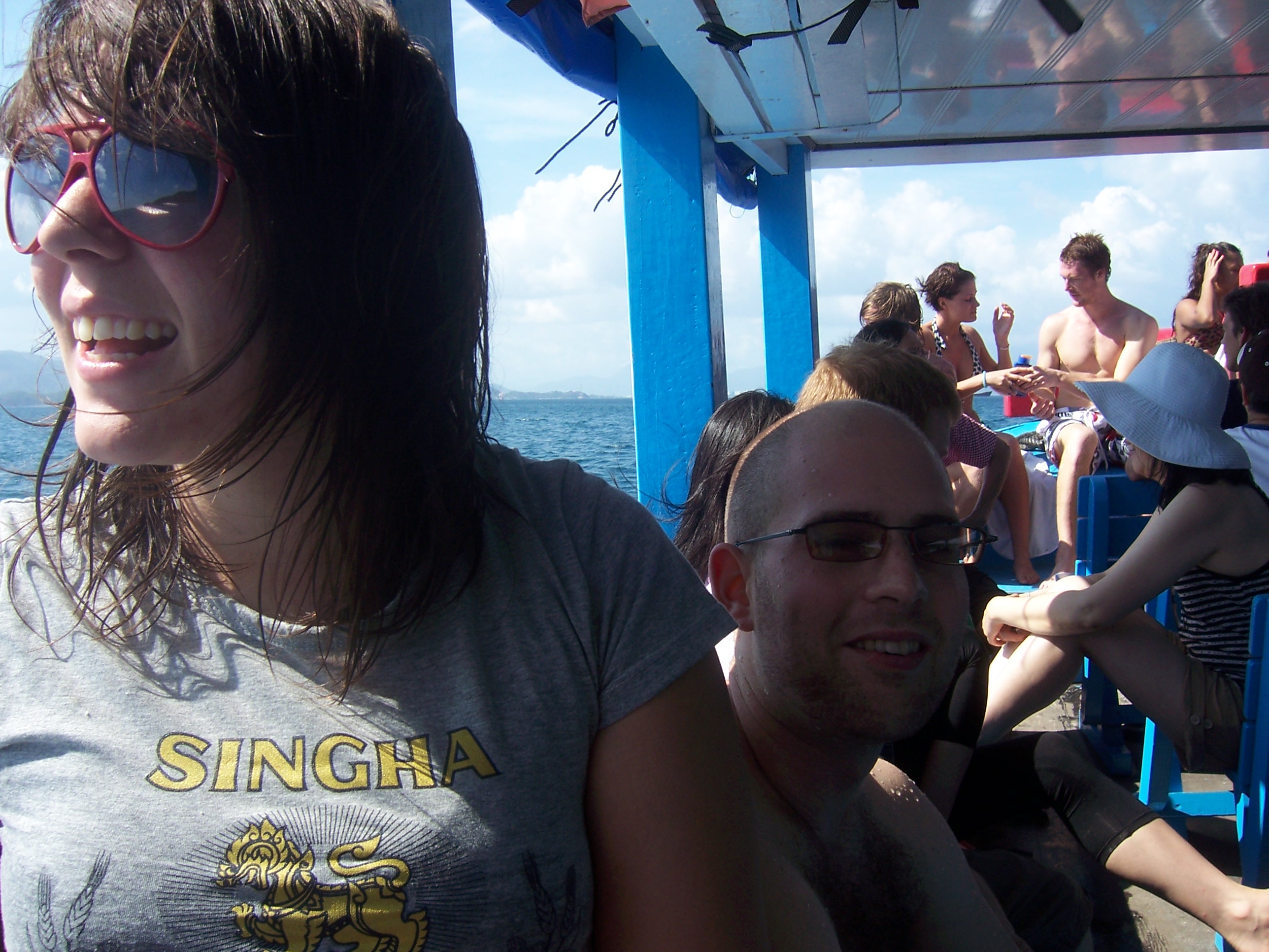 Miriam smiling on deck, other travellers behind